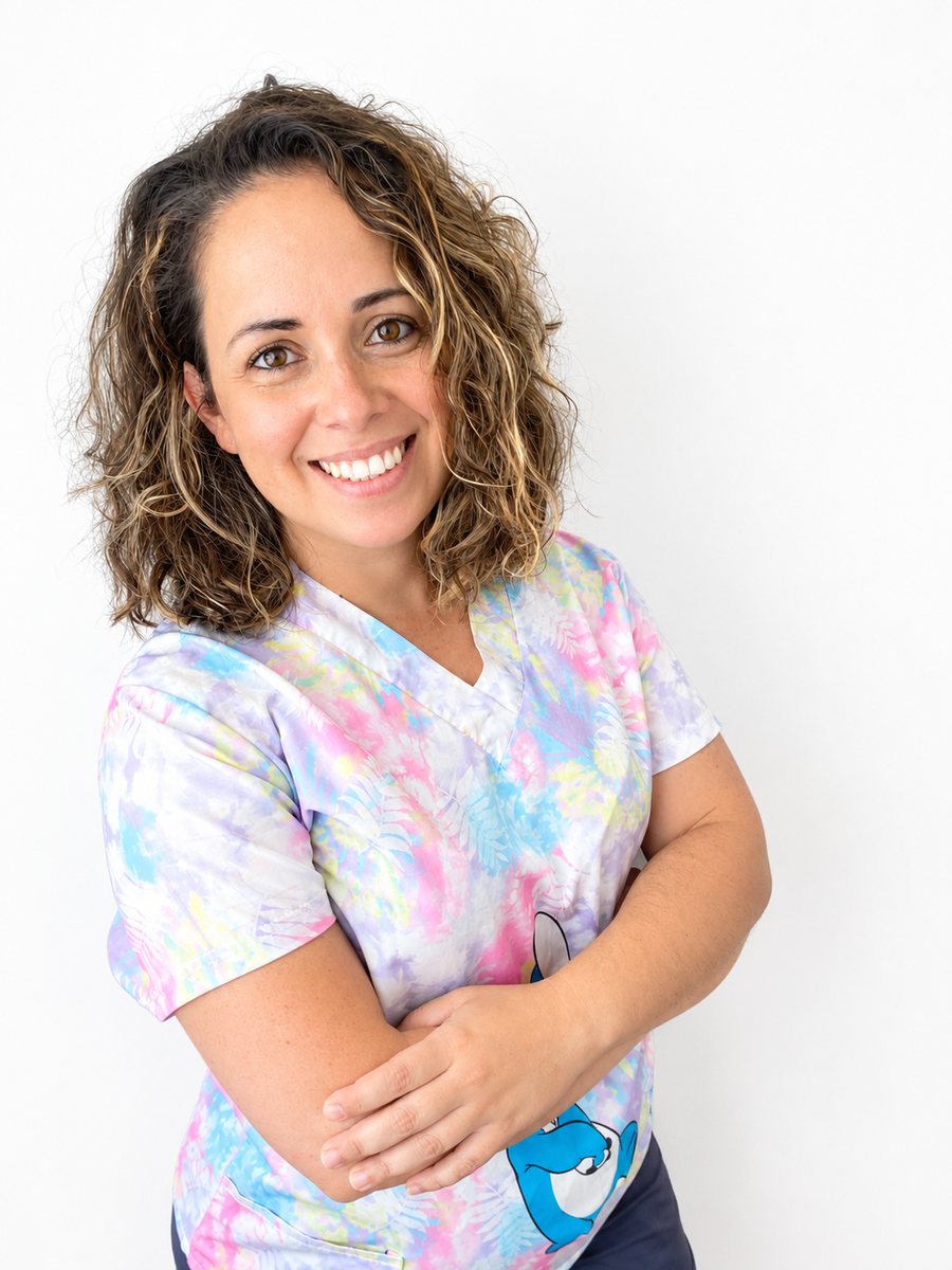 La Dra. Layra González Cusidó, odontopediatra en Tenerife, sonriendo con su uniforme de colores